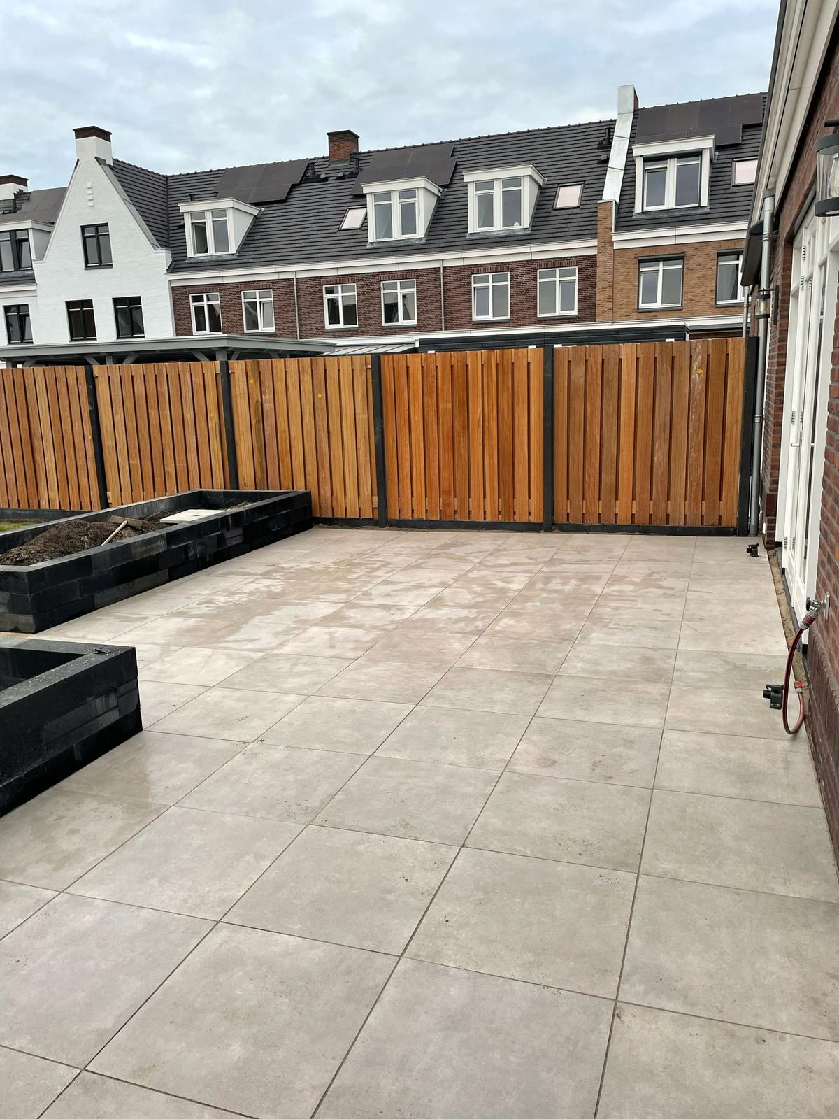 Strak bestraat terras met houten schutting