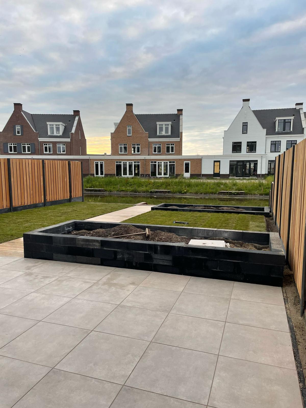 Terras met gazon, verhoogde borders en houten omheining
