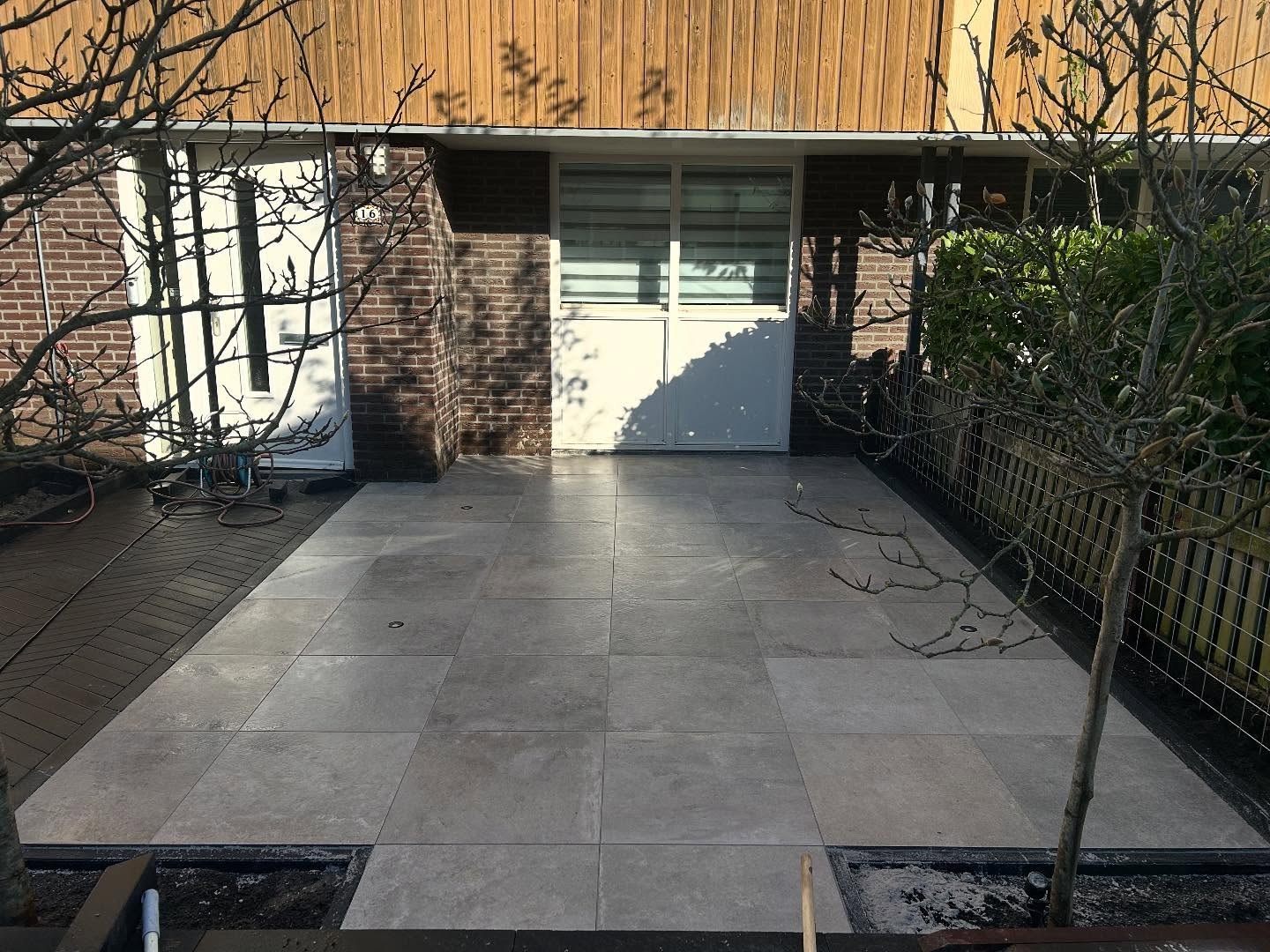 Beplanting tussen bestrating en omheining in een gerenoveerde tuin in Zoetermeer