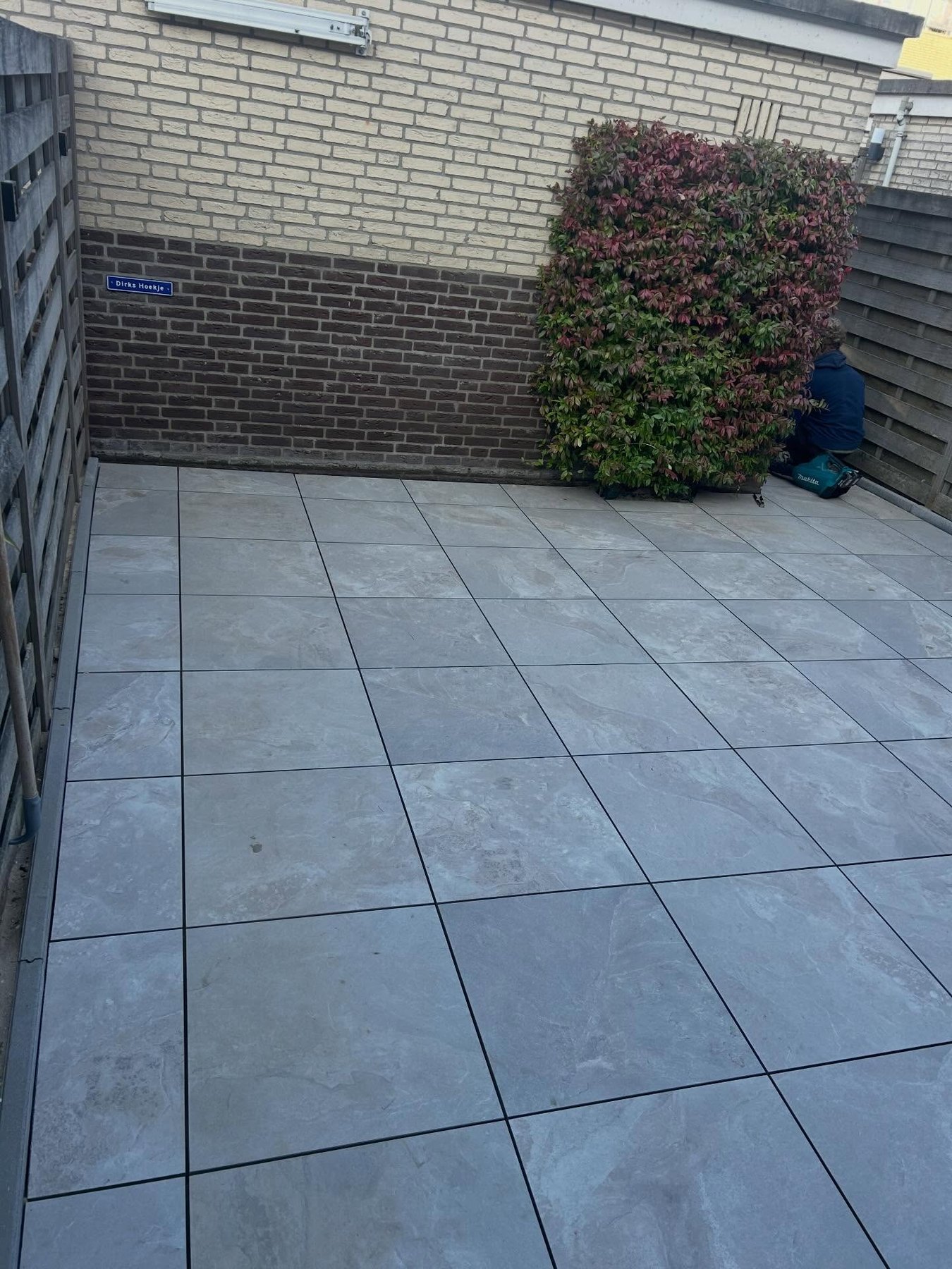 Afgeronde bestrating met grote tegels in een tuin in Zoetermeer